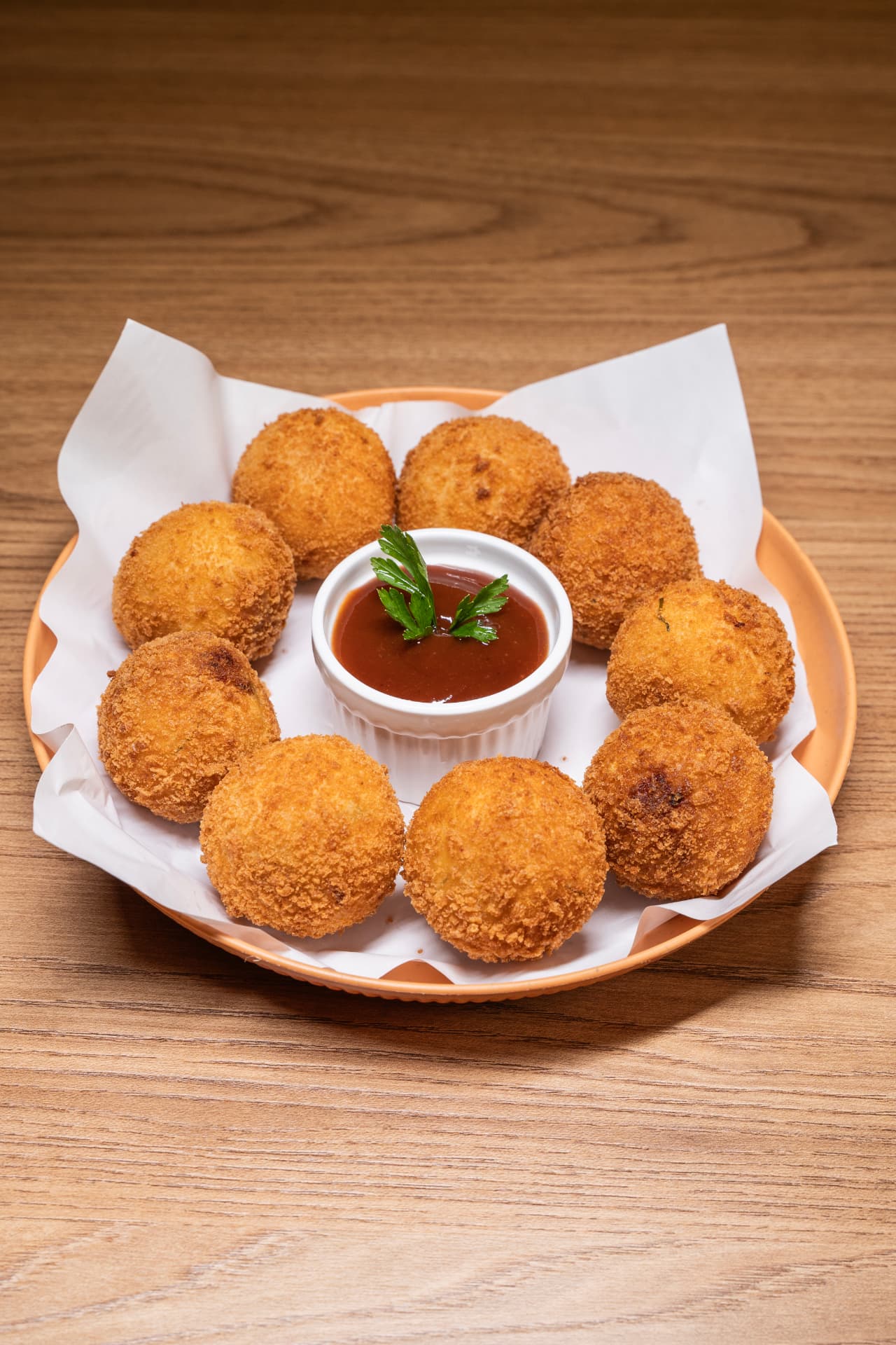 Porção de bolinhos crocantes com molho ao centro