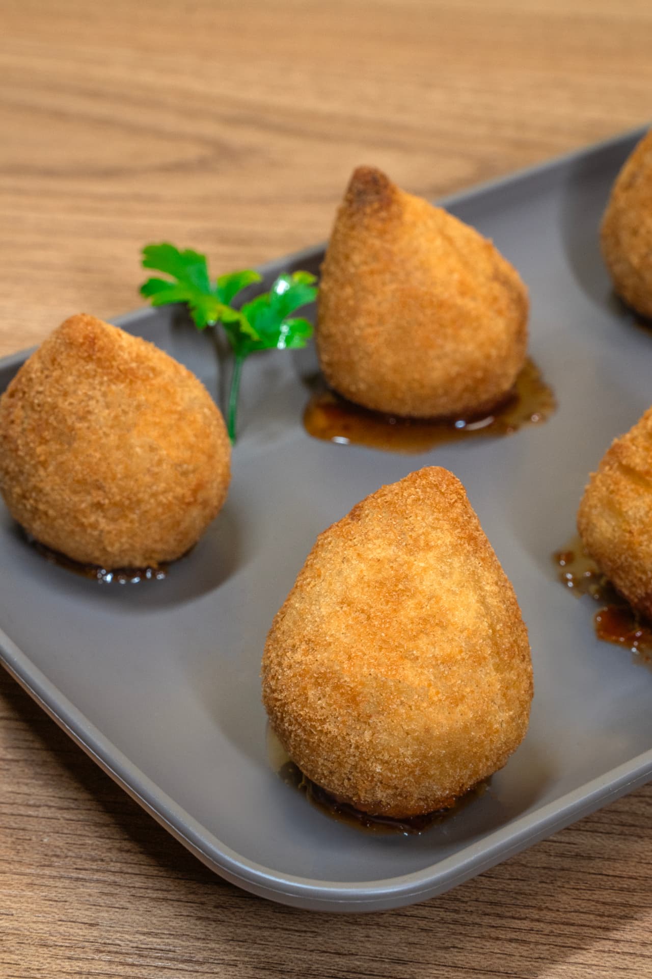 Coxinhas de costela douradas servidas em travessa